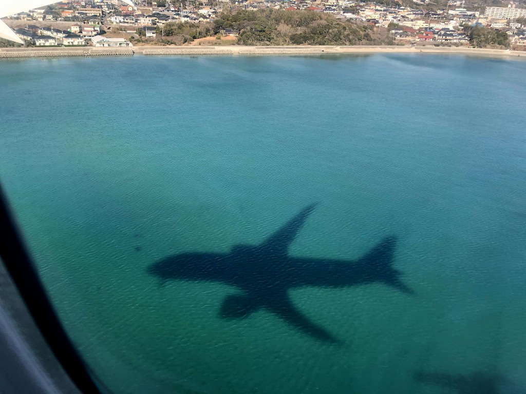 海に映るANA693便の機影
